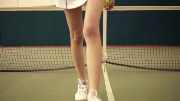 短いブロンドの髪と優れた図のカメラ、スローモーション、歩く若い女性のテニス プレーヤー カバー屋内裁判所の映像 — ストック動画
