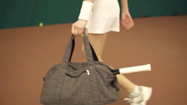 バッグとテニス ラケットおよび裁判所の訓練のための準備の若いフィット女性の足のクローズ アップ ビュー — ストック動画