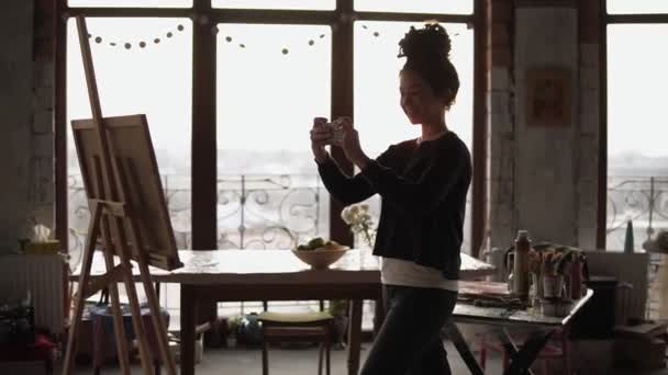 Lány figyelembe képet a festmény, magához húzta a lány smartphone. — Stock videók