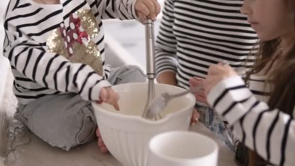 Las hijas están amasando la masa con su madre en la cocina — Vídeo de stock