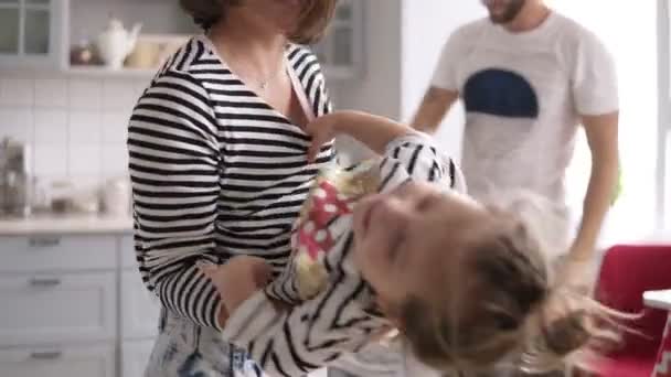 Moeder houdt een dochtertje in haar armen, een andere dochter verblijf met papa en glimlach — Stockvideo