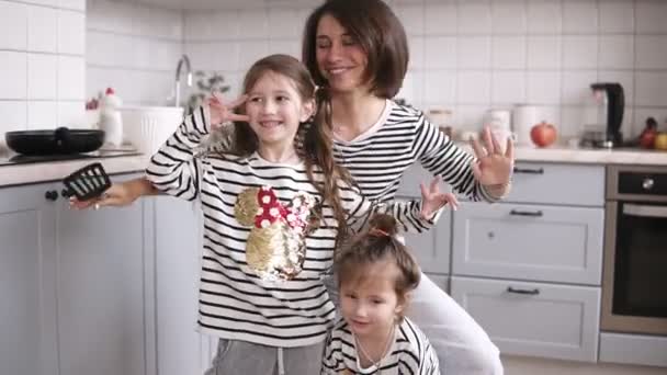 Madre y dos hijas bailan en la cocina — Vídeo de stock