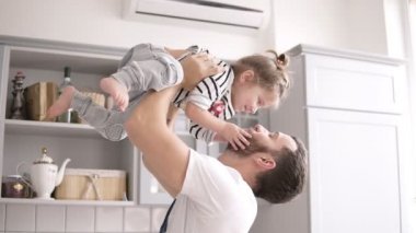 Baba küçük kızı mutfakta onun kollarında tutar, kızı babası mutfak kisses