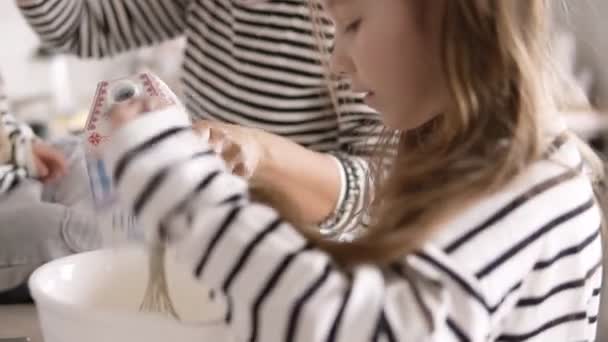 Dochter is het kneden van het deeg met haar moeder en zus op de keuken — Stockvideo