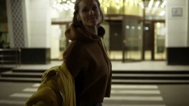 Airily gece sokakta dans kaygısız gülümseyen kadın. Kısa sarı saçlı başını sallayarak