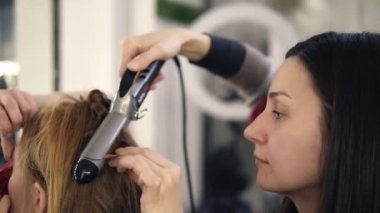 Prepation işlemi gourgeous genç kadın. Kuaför uzun sarı saçlar visage bitirme culring çubuk ve makyaj sanatçısı ile büküm