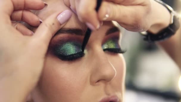 Toques finais de trabalho visagista para completar os olhos verdes compõem uma mulher linda. Sombras brilhantes — Vídeo de Stock