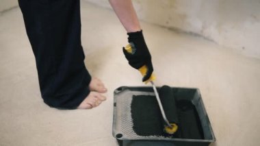 Kız Boyama duvar siyah boya ile oda içinde roller ile o duvarın duruyor. Ağır çekim