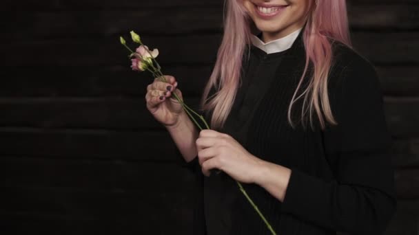 Gros plan d'une superbe jeune femme aux cheveux longs choisit des fleurs pour un bouquet. Tulipes violettes — Video