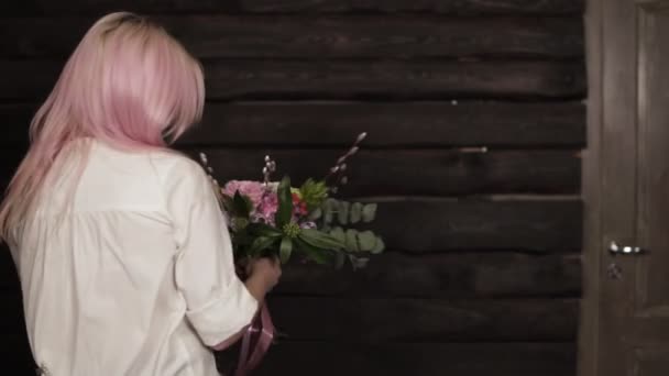 Tendre, belle fille tourbillonne avec des fleurs dans les mains, profitant de la beauté d'un bouquet. Fond sombre — Video