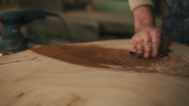 De timmerman met een doek in zijn hand verwerkt het hout met olie na grindering. Close-up — Stockvideo