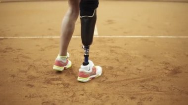 Aşağıdan yukarıya bir spor tenis oynamaya fiziksel engelli uzun saçlı kadın görüntüleri. Yakın çekim