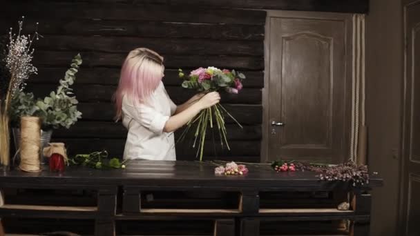 Professionelle Floristin in weißem Hemd dekoriert einen modischen Strauß, der mit Blumen für die perfekte Komposition ergänzt wird. Gegenwind — Stockvideo