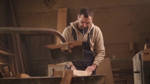 Przodu, bliska footage Piłowanie drewna na maszynie z żyłką. Stolarz w kombinezon — Wideo stockowe