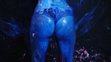 Seksi genç kadın twerk yapma mavi poposunu sallayarak. Mavi boya ile Spreded