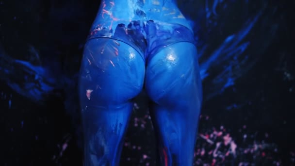 Sexy joven mujer sacudiendo su culo azul, haciendo twerk. Esparcida con pintura azul — Vídeo de stock