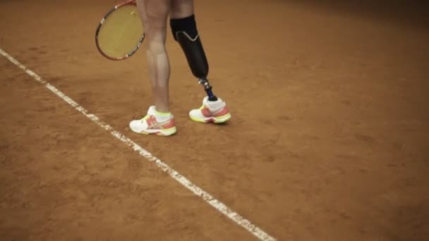 Magnífico metraje en cámara lenta de una impresionante mujer alta sirviendo la pelota. Mujer discapacitada — Vídeo de stock