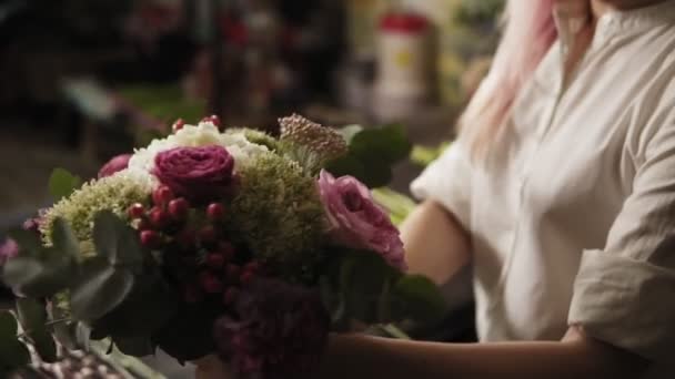 Ein bunter Strauß modisch flatternder Blumen in den Händen der Mädchen. gedämpftes Licht. Nahaufnahme — Stockvideo