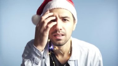 Noel Baba 'nın kırmızı şapkalı genç ve çekici adamının yakın çekim görüntüleri ya da uzun bir gece boyunca kamera aynasına bakıp yüzüne dokunurken kendini tanıması, Preen. Arkaplan maviye izole edildi