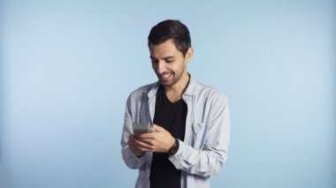 Genç mutlu adam kağıt para ve dolar banknotları aldı. Mavi duvarın önünde gündelik kıyafetlerle para saymak. Parayı nakit al, parayı kazan, hediye konseptini al. Erkek el ele tutuşur ve...