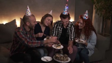 Karanlığa gömülmüş, süslenmiş, kanepede oturmuş doğum günü pastası yiyen pozitif adamlar. Doğum günü çocuğu arkadaşının tabağına lezzetli pastalar koyuyor. Doğum günü kutlaması