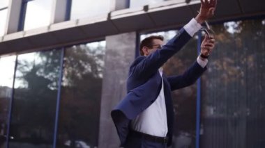 Mavi takım elbiseli mutlu genç bir işadamı çıkışa doğru yürür ve havaya bir avuç dolusu banknot atar. Gözlüklü süper heyecanlı işadamları ofis binasının önüne para atıp başarıyı kutluyorlar.