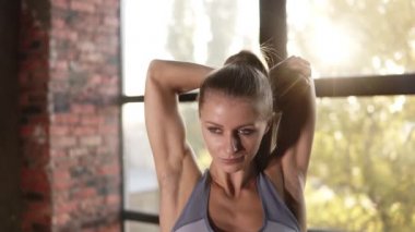 Güzel bir kadın pilates egzersizi yapıyor. Kapalı alan eğitim stüdyosunda kollarını esnetiyor. Spor salonundaki kadın sabah antrenmanında esneme egzersizi yapıyor. Spor insanları konsepti