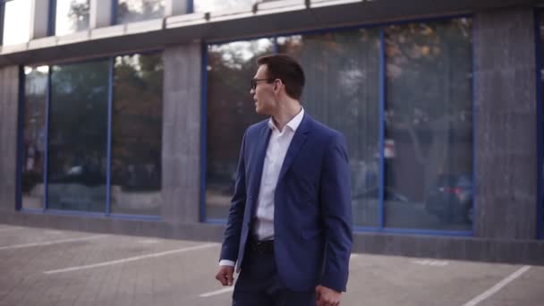 Young businessman looking around to sure noone see him and starts to express his feeling about victory and big success on the street near the office center wearing suit celebrating his achievements — Stock Video