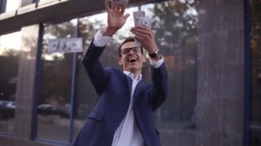 Mavi takım elbiseli Kafkas işadamı havaya bir avuç banknot fırlattı. Gözlüklü süper heyecanlı işadamları ofis binasının önüne para atıp başarılı bir projeyi kutluyorlar.