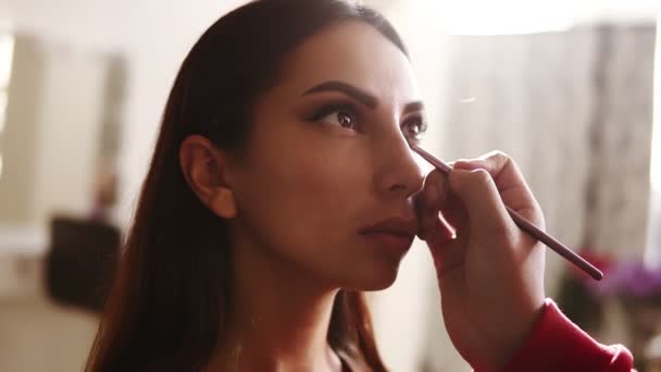Perfektní scéna nepoznatelné ženské make-up umělkyně, která aplikuje a kombinuje modely dolních víček s očními stíny. Proces vytváření dokonalých kouřových očí tvoří vzhled. Objektiv světlice na pozadí — Stock video