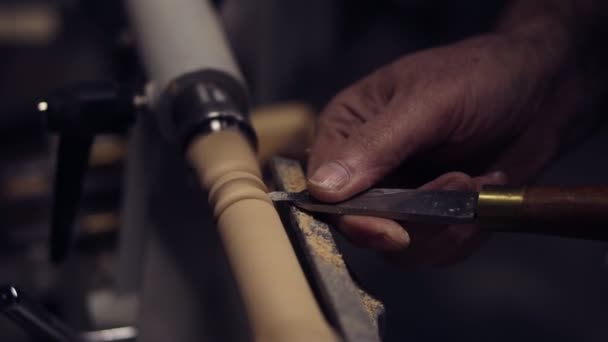 Плотник мужских рук вырезает деревянную ручку из деревянного куска, крутящегося на машине зубилом, крупным планом. Медленное движение. Вид сбоку — стоковое видео