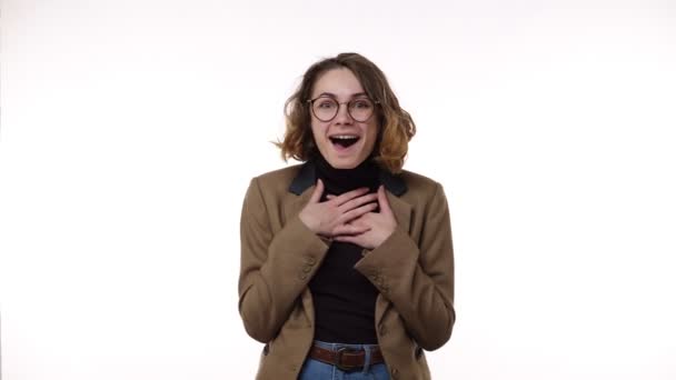 Over excited female with curly hairstyle, laughs happily, expresses sincere emotions, being amused by good news. Happy young female in jacket and jeans gesturing, super surprised — Stock Video