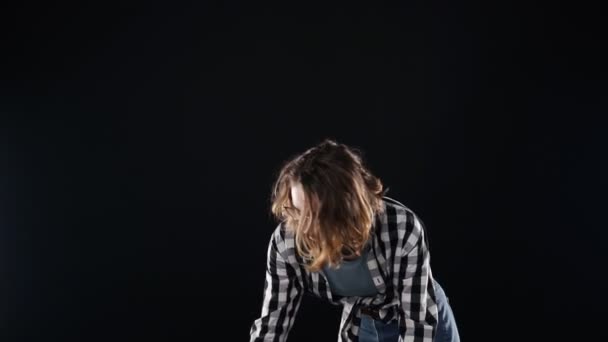 Cropped footage of a young woman sweeps garbage with a broom in the scoop. Cleaning concept. Isolated over black background — Stock Video