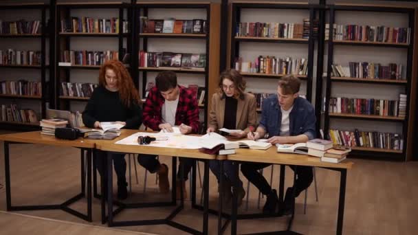 Zeitlupe von Studenten, die nach Stunden des Studiums in der Uni-Bibliothek die Blätter hochwerfen. glückliche und freie Studenten, die nicht studieren wollen oder den Beginn der Ferien feiern — Stockvideo