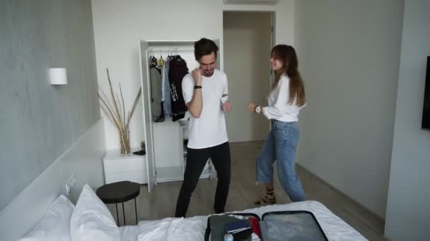 Deux personnes modernes cool s'amusant ensemble en vacances ou avant. Jeune beau couple drôle en amour dansant ensemble à l'hôtel. Bon style de vie. Voyage. Valise à l'avant-garde — Video