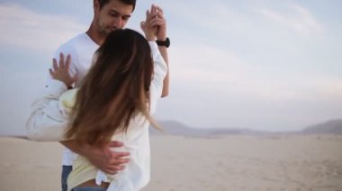 Hoş, neşeli, sıradan beyaz tişörtler giyen bir çift. Koyu saçlı adam sevgilisiyle dönüyor, el ele tutuşuyor. Boş çölde doğada dans etmek. Şehvetli hareketler. Yavaş çekim