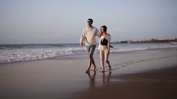 Couple promenade romantique sur la plage, amoureux marchant pieds nus sur le sable. Été, couple amoureux, vacances exotiques, vent agitant les cheveux féminins, fond sable et eau, temps ensoleillé — Video