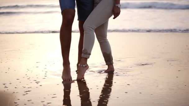 Casal de amantes homem e mulher pintar com os pés no coração de areia molhada. Gravações de casais amorosos na costa do mar. Movimento lento — Vídeo de Stock