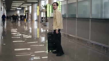 Bavullu sakallı genç adam, kız arkadaşını bekliyor, uzun bir ayrılıktan sonra iş gezisinden eve dönüyor. Erkek, kız arkadaşına sarılıp onu kucağına alıyor.