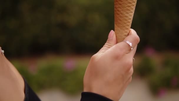 Primer plano de material de archivo morena sensual chica lamiendo helado en un cono - blanco y amarillo cucharadas. Sensual lamer el helado derretimiento con la lengua. Capturado en vista lateral. Fondo borroso — Vídeos de Stock