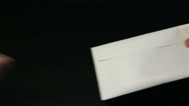 Yakın çekim kadının el için para zarfı veren el mans. Siyah arka plan. Transfer nakit el el. Eller açık bir zarf ve bir sürü 20 İngiliz Lirası Gbp banknot sayma.