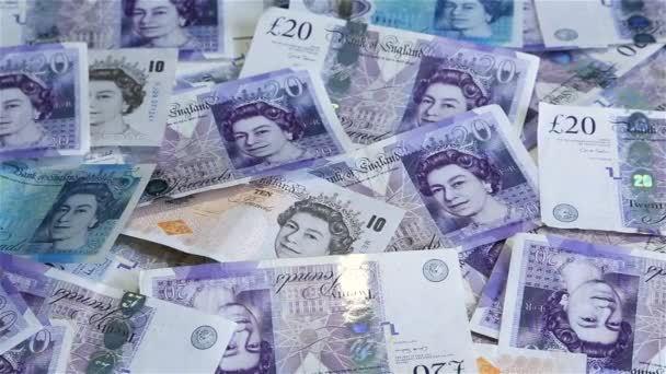 Close-up dolly shot de papel britânico espalhado e notas de dinheiro de plástico com uma variedade de denominações . — Vídeo de Stock