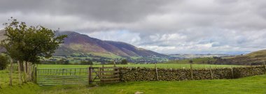 Taş duvar dağ Lake District olarak arka planda yeşil alanlarla arasında Kuru