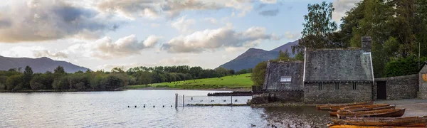 Derwentwater, İngiltere'nin kıyısında ahşap tekneler üzerinde günbatımı panoramik manzaralı