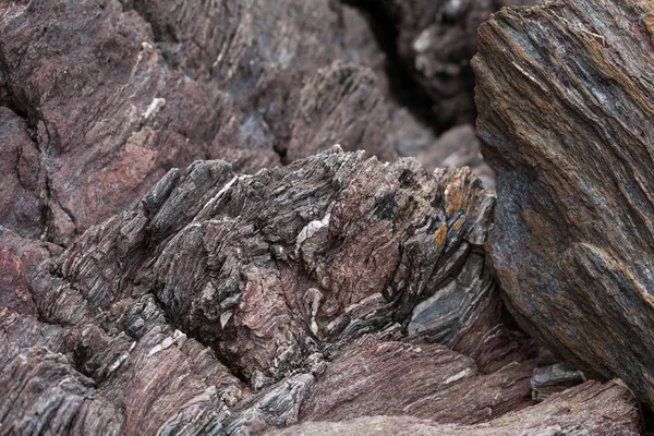 Трещины и красочные слои коричневого камня в качестве фона — стоковое фото