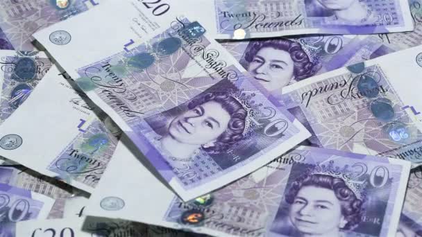Pénznem, Egyesült Királyság. Közeli kép: leeső pénzt. 20 kiló Gbp bankjegyek szétszóródott az asztalon. — Stock videók