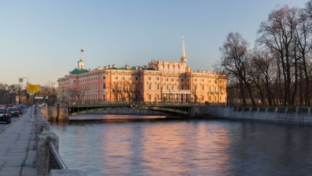 Timelapse van Engineer's kasteel (kasteel van de Mikhailovski of St. Michael's) uitzicht vanaf de dijk van de rivier Fontanka, boten varen langs het kanaal, wolkenloze hemel, zonsondergang, St. Petersburg, Rusland — Stockvideo