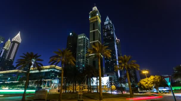 Dubai Financial Center, pencakar langit dengan penerangan malam, lalu lintas mobil di bundaran dekat Emirates Towers, UEA — Stok Video