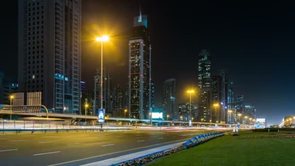 Tráfego de carros na estrada Sheikh Zayed à noite no centro da cidade, arranha-céus com iluminação noturna. Dubai, Emirados Árabes Unidos — Vídeo de Stock