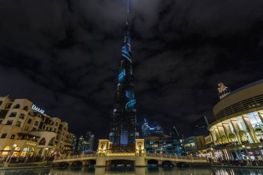 Uluslararası Dubai Kongre ve Sergi Sarayı manzarası ile gece aydınlatma ve Dubai Mall alışveriş merkezine ve Souk Al Bahar yakın bir köprü. Dubai, Birleşik Arap Emirlikleri.